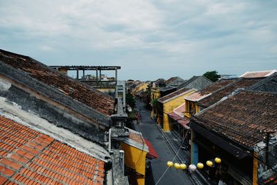 High angle view of houses by building against sky