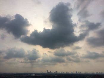 Low angle view of city against cloudy sky