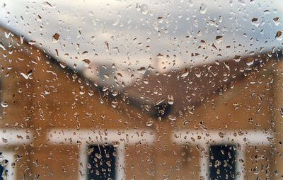 Full frame shot of wet glass window in rainy season