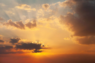 Beautiful vibrant orange sunrise sky with sun rays