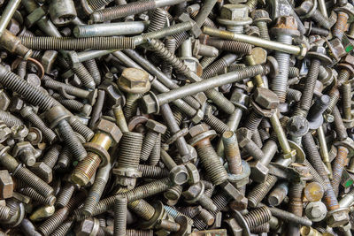 Full frame background of used automobile bolts heap, old and dirty