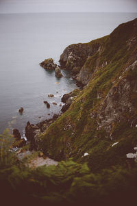 Rocks on sea shore against sky