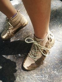 Low section of woman wearing shoes standing outdoors