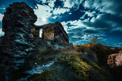 Low angle view of castle on mountain against sky