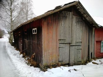 Frozen house against sky during winter