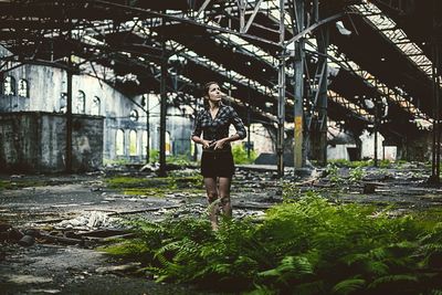 Full length portrait of woman standing against trees