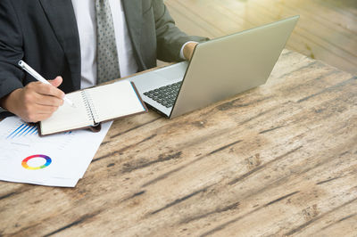 Low angle view of man using mobile phone on table