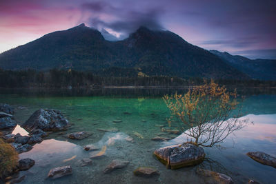 Scenic view of lake by mountains against sky