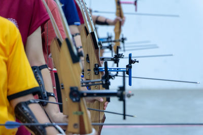 People holding bow and arrow against sea and sky