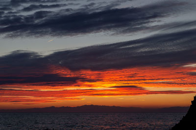 Scenic view of dramatic sky over sea during sunset