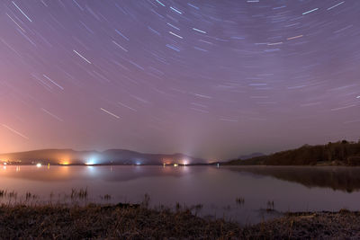 Scenic view of lake against sky at night