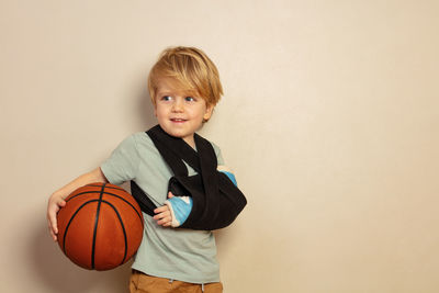 Portrait of boy playing basketball at home