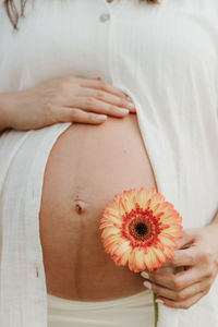 Midsection of woman holding flower