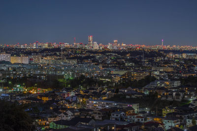 Illuminated cityscape against sky at night