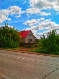 Road by house against sky