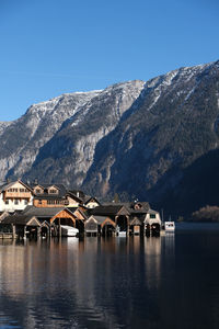 Scenic view of lake and mountains against clear blue sky