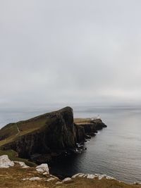 Scenic view of sea and cliff against sky