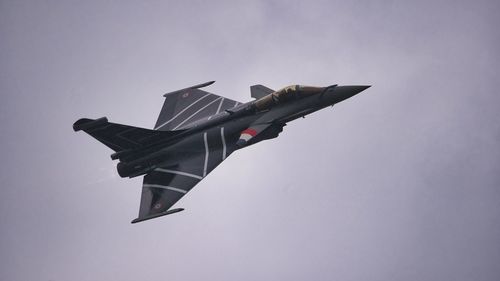 Low angle view of dassault rafale flying against clear sky