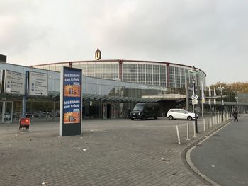 Vehicles on road against sky in city