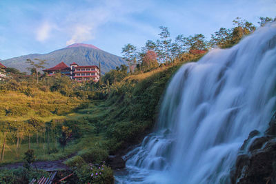 Scenic view of waterfall against sky