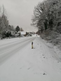 Tire tracks on road against sky during winter