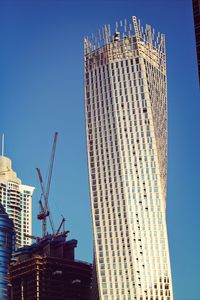 Low angle view of modern building against clear blue sky