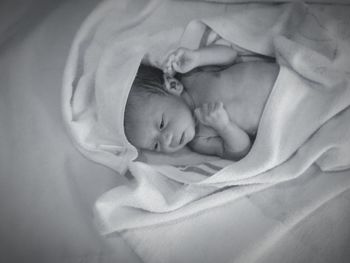 High angle view of cute newborn baby on bed