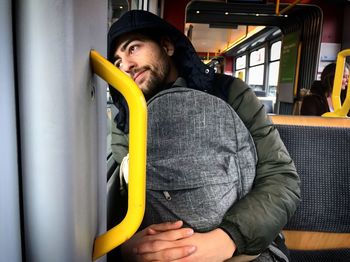 Man wearing warm clothing while sitting in bus