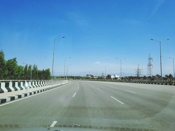 Road by highway against blue sky