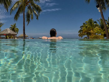 Man swimming in pool against sea