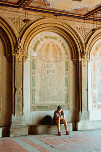 Full length of woman sitting in temple