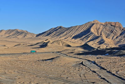 Scenic view of desert against clear blue sky