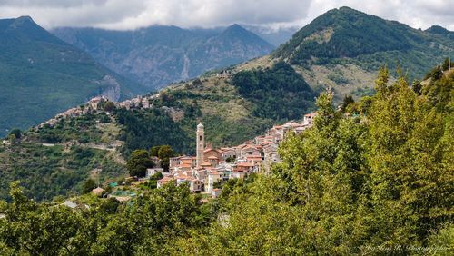 Scenic view of townscape and mountains against sky