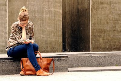 Full length of woman sitting on bench