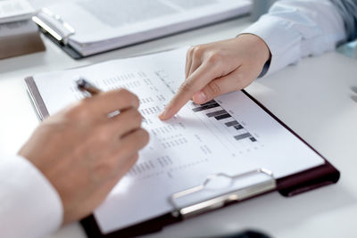 Midsection of businessman working on blueprint