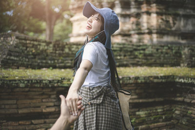 Side view of woman standing against blurred trees