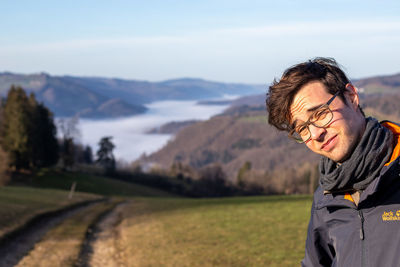 Portrait of young man against mountains against sky