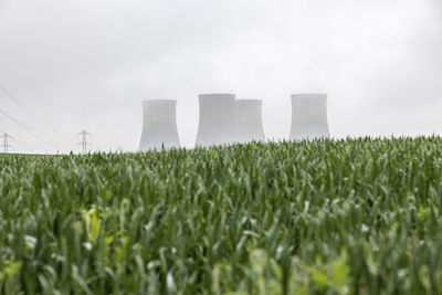 Uk, england, rugeley, large cooling towers during foggy weather with field in foreground