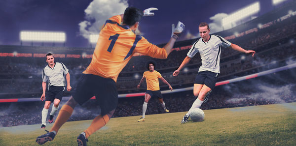 Men playing soccer on field