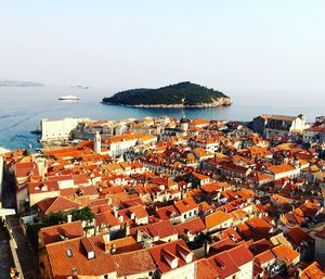 High angle view of buildings in town by sea