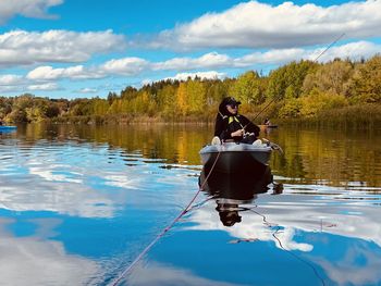 Rear view of man sailing boat in lake