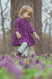 Portrait of young woman standing amidst flowers