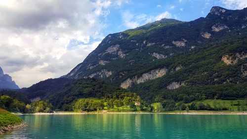 Scenic view of mountains and lake against cloudy sky