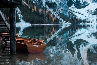 Boat moored in lake against mountain