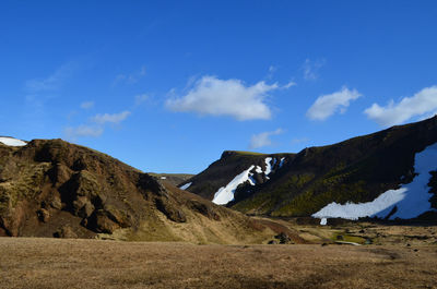 Spring thaw with snow patches on mountains surrounding a valley in remote iceland.