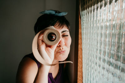 Portrait of young woman holding camera