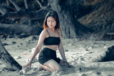 Full length of woman sitting on sand