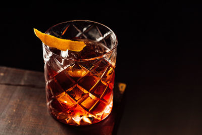 Close-up of drink in glass on table against black background