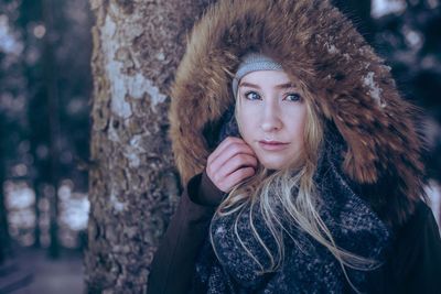 Close-up portrait of young woman in forest during winter