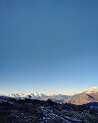 Scenic view of snowcapped mountains against clear blue sky